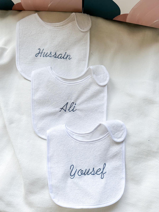 White bib with blue embroidery